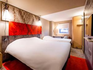 Habitación de hotel con 2 camas y alfombra roja en ibis Bordeaux Centre Meriadeck en Burdeos