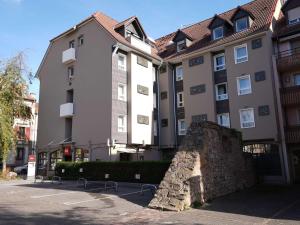 a building with a stone wall in front of it at ibis Colmar Centre in Colmar