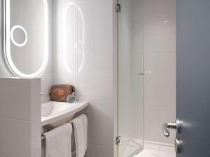 baño blanco con ducha y lavamanos en ibis Paris Rueil Malmaison, en Rueil-Malmaison