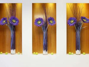 un groupe de fleurs violettes dans des vases sur une étagère dans l'établissement ibis Styles Luzern, à Lucerne