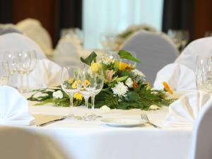 a table with wine glasses and a flower arrangement on it at ibis Styles Luzern in Luzern