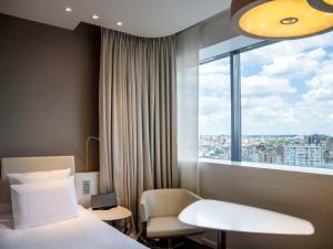 a hotel room with a bed and a window at Pullman Brussels Centre Midi in Brussels