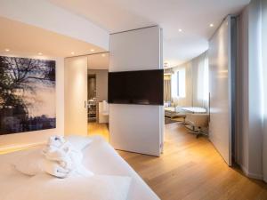 a bedroom with a white bed and a bathroom at Pullman Brussels Centre Midi in Brussels