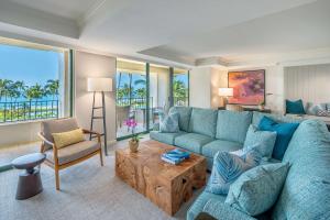 a living room with a blue couch and a table at Grand Hyatt Kauai Resort & Spa in Koloa