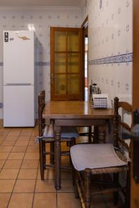 eine Küche mit einem Holztisch und einem Kühlschrank in der Unterkunft Casa Can Rufo de Rupit in Rupit