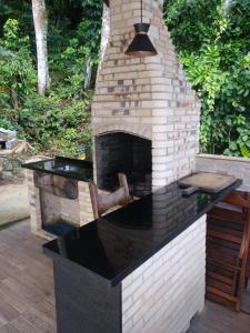 an outdoor kitchen with a brick oven in a yard at Casa Martureza in Angra dos Reis