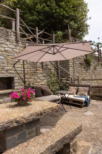 a patio with an umbrella and a couch and a table at Casa Can Rufo de Rupit in Rupit