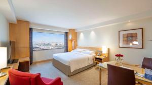 a hotel room with a bed and a desk with a computer at Hyatt Regency Dubai - Corniche in Dubai