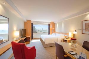 a hotel room with a bed and a desk and a table at Hyatt Regency Dubai - Corniche in Dubai