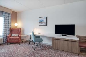 a hotel room with a desk with a television and a chair at Hilton Garden Inn Clarksburg in Clarksburg