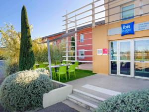 a restaurant with a table and chairs outside of a building at ibis budget Saint-Maximin in Saint-Maximin-la-Sainte-Baume