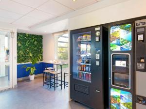 a vending machine in a room with a table at ibis budget Saint-Maximin in Saint-Maximin-la-Sainte-Baume