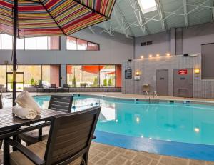 a large swimming pool with a table and chairs next to it at Best Western Premier Alton-St Louis in Alton