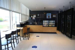 a restaurant with a bar with chairs and a counter at Ramada By Wyndham Soma in Soma