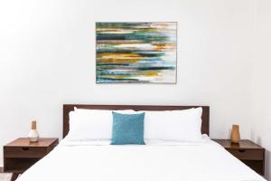 Un dormitorio con una cama blanca y una pintura en la pared en Villa Blue Amber Cabarete, en Cabarete