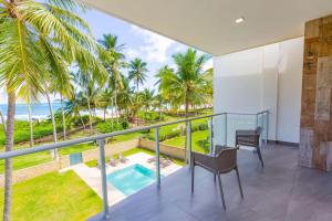 a balcony with a view of the beach and palm trees at Villa Blue Amber Cabarete in Cabarete