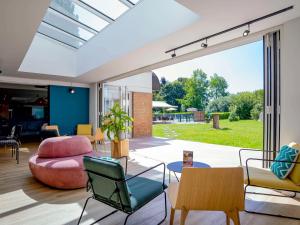 sala de estar de planta abierta con sillas y sofá en ibis Styles Lille Neuville en Ferrain, en Neuville-en-Ferrain