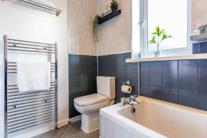 a bathroom with a tub and a toilet and a sink at New Large 2 Bed entire apartment Near Newcastle upon Tyne with Free Parking in Kenton +31 photos