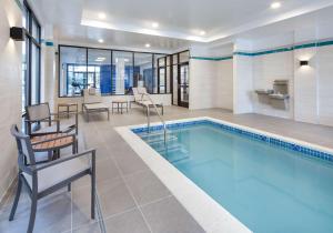 a pool in a hotel with chairs and a table at Hyatt Place Newark-Main Street in Newark