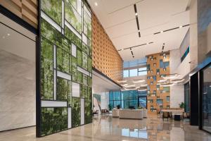 an office lobby with a green wall at Hilton Garden Inn Shenzhen Guangming Hongqiao Park in Shenzhen
