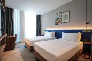 a hotel room with two beds and a desk at Hilton Garden Inn Ankara Dikmen in Ankara