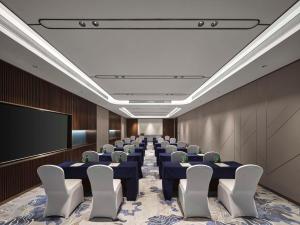 a conference room with tables and chairs and a screen at Hilton Garden Inn Nantong Rudong in Nantong
