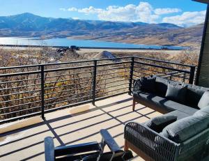 un sofá y sillas en una terraza con vistas a las montañas en The views! Enjoy this Hideout home., en Keetley