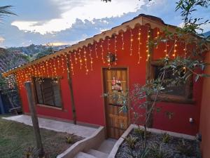 uma casa vermelha com luzes de Natal em Chalé Sunset em Miguel Pereira