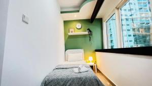 a bedroom with a bed and a green wall at Dreamy Partition Room in Barsha1 in Dubai