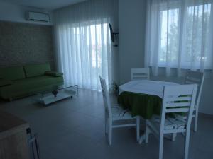 a living room with a table and chairs and a couch at Villa Simfonija in Malinska