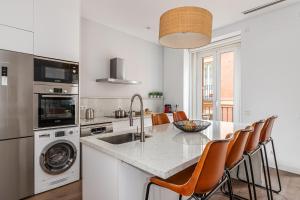 cocina con fregadero y mesa con sillas en BNBHolder The Superb SOL, en Madrid