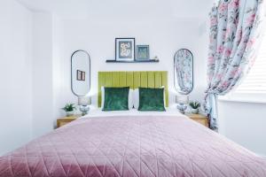 コベントリーにある3Bed Luxury Retreat - Your Perfect Coventry Holiday Home Awayのベッドルーム1室(ピンクのベッドカバー付きの大型ベッド1台付)