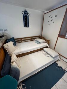 a room with two beds and a chair in it at Casa na Beira da Praia da Pipa Beach House Luxury in Pipa