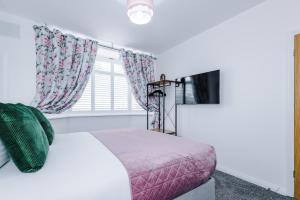 een slaapkamer met een bed en een raam bij 3Bed Luxury Retreat - Your Perfect Coventry Holiday Home Away in Coventry