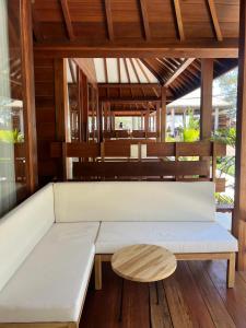 a white couch and a wooden table in a room at Villa Penyu Gili Trawangan in Gili Trawangan