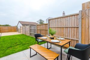 patio z drewnianym stołem i krzesłami w obiekcie 3Bed Luxury Retreat - Your Perfect Coventry Holiday Home Away w Coventry