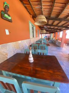 uma sala de jantar com uma mesa de madeira e cadeiras em Vila Vitória Pousada em Pirenópolis