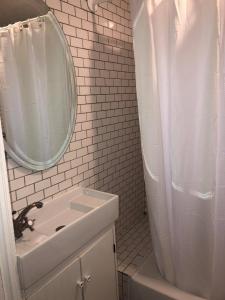 a white bathroom with a sink and a mirror at DTLA Oasis Private Bedroom with Exclusive Laundry - Steps to the Heartbeat of LA in Los Angeles