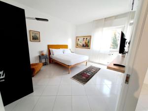 Habitación blanca con cama y ventana en Casagè, en Salerno