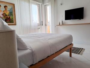 1 dormitorio con 1 cama y TV en la pared en Casagè, en Salerno