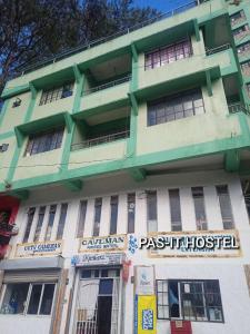 a green and white building with a sign in front of it at Pas-it Hostel Sagada in Sagada