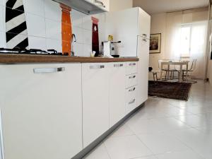 cocina con armarios blancos y mesa en Casagè, en Salerno