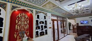 una habitación con una pared roja con pinturas. en Hotel Ansi Boutique W&S terrace en Bukhara