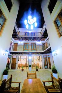 Cette grande chambre dispose d'une table, de chaises et d'un plafond. dans l'établissement Hotel Ansi Boutique W&S terrace, à Boukhara