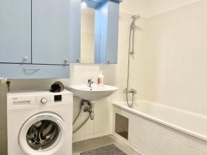 een badkamer met een wasmachine en een wastafel bij 90 m2 Maisonette with Free Parking in Wenen