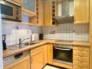 a kitchen with wooden cabinets and a sink at 90 m2 Maisonette with Free Parking in Vienna