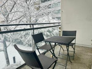 two chairs and a table on a balcony with snow covered trees at 90 m2 Maisonette with Free Parking in Vienna