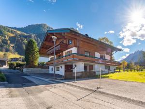 a large wooden house on a hill with mountains at Haus Kitzblick XL in Kaprun