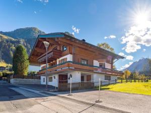 a large wooden house with mountains in the background at Familienchalet Kitzblick in Kaprun