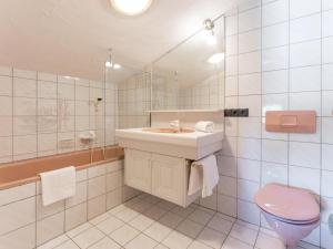 a bathroom with a sink and a toilet and a mirror at Familienchalet Kitzblick in Kaprun +23 photos